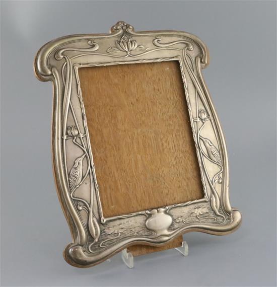 An Edwardian Art Nouveau repousse silver mounted photograph frame by William Neale, Birmingham, 1906, 32cm.